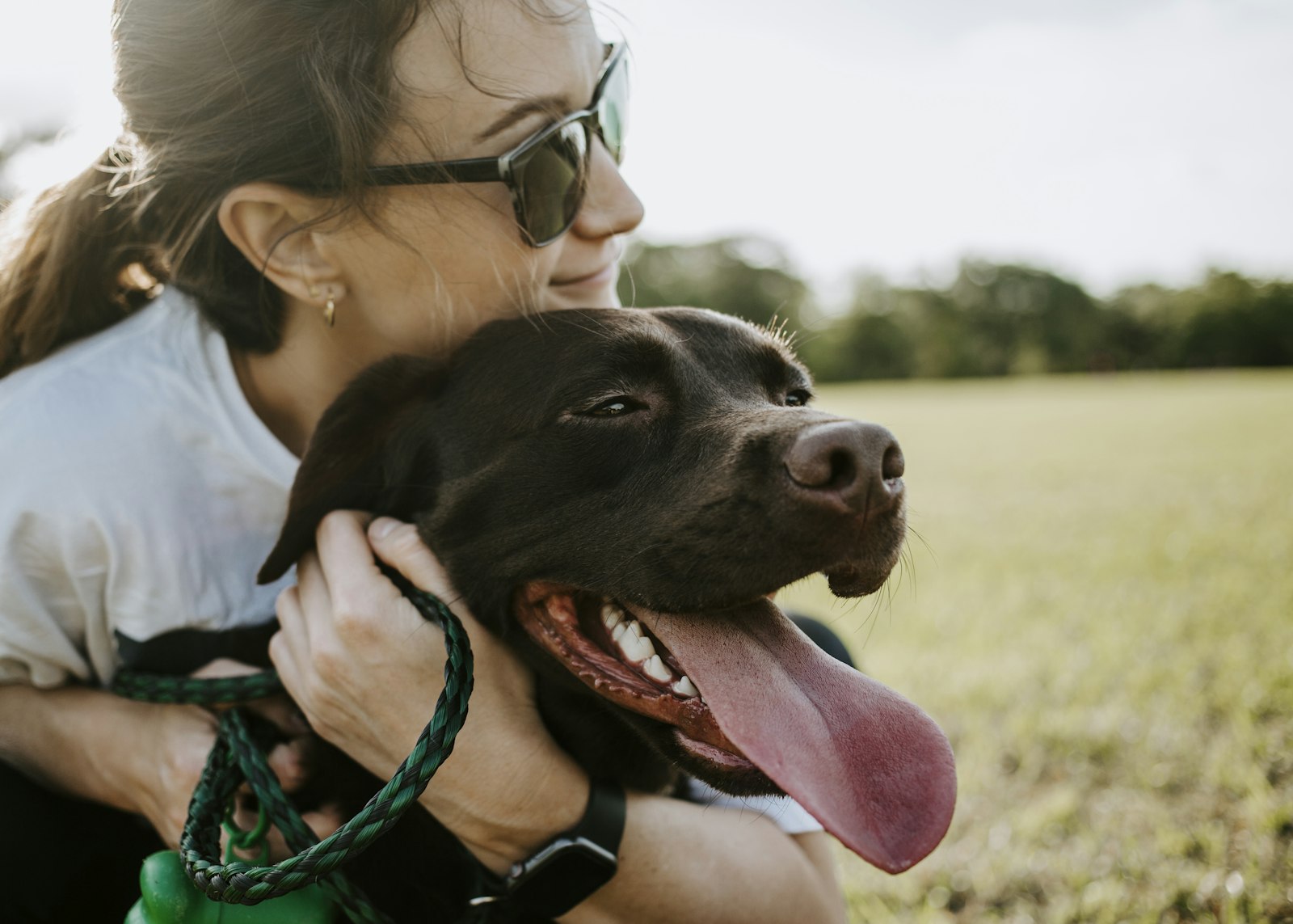 Happy pet owner hugging her dog outdoors