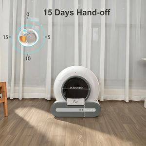 A white and gray automatic pet litter box sits on a wood floor in front of sheer white curtains. Text on the image reads '15 Days Hand-off' with a circular inset showing the lid's tilt sensor.
