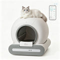 A white and gray automatic cat litter box with a fluffy white cat lying on top, shown on a clean white background with a smartphone app screen graphic in the upper right.